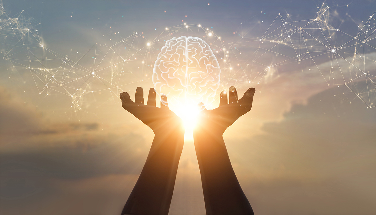 Avoimet kämmenet, jotka pitelevät virtuaalisia aivoja, taustalla auringonlasku.