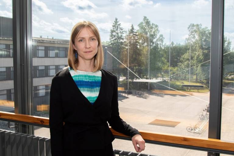 Smiling woman in front of a window.