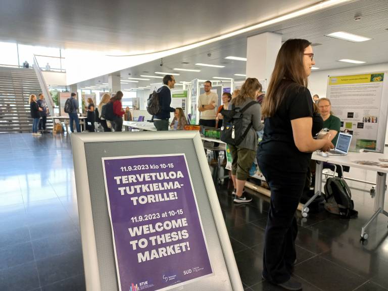 Students and stakeholders having conversations at the Thesis Market.