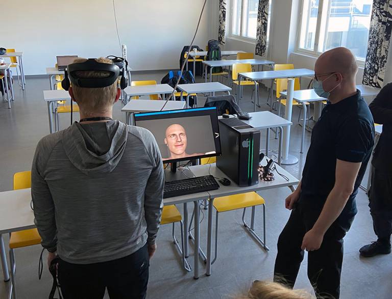 Henkilö kokeilee virtuaalilaseja luokkahuoneessa.