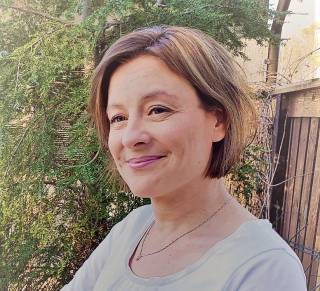 Hymyilevä polkkatukkainen nainen.