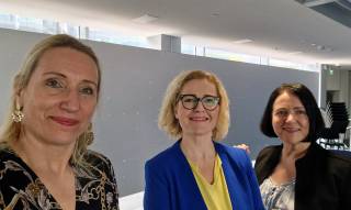 Kolme naista kuvattuna sisätiloissa. 