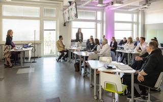 People in a classroom listening to a presenter. 