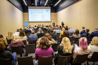 A presenter in front of a big audience.