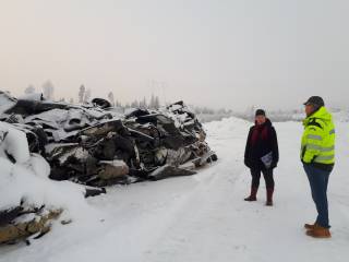 Bitumakatejätekasan vieressä ihmisiä