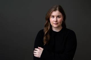 Young, dark haired woman in black shirt.