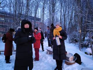 Ihmisiä glögimukien ja termoskannun kanssa Metsälämpäreellä