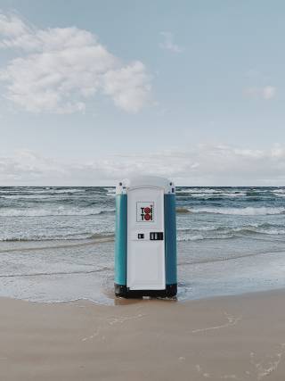 A lone porta-loo standing on a sea shore