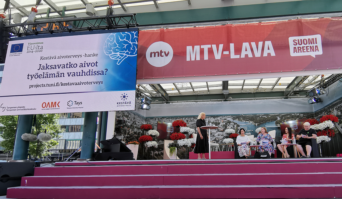 Viisi naista ulkona esiintymislavalla.