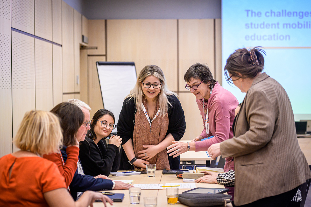 Seven women gathered around the table to plan.