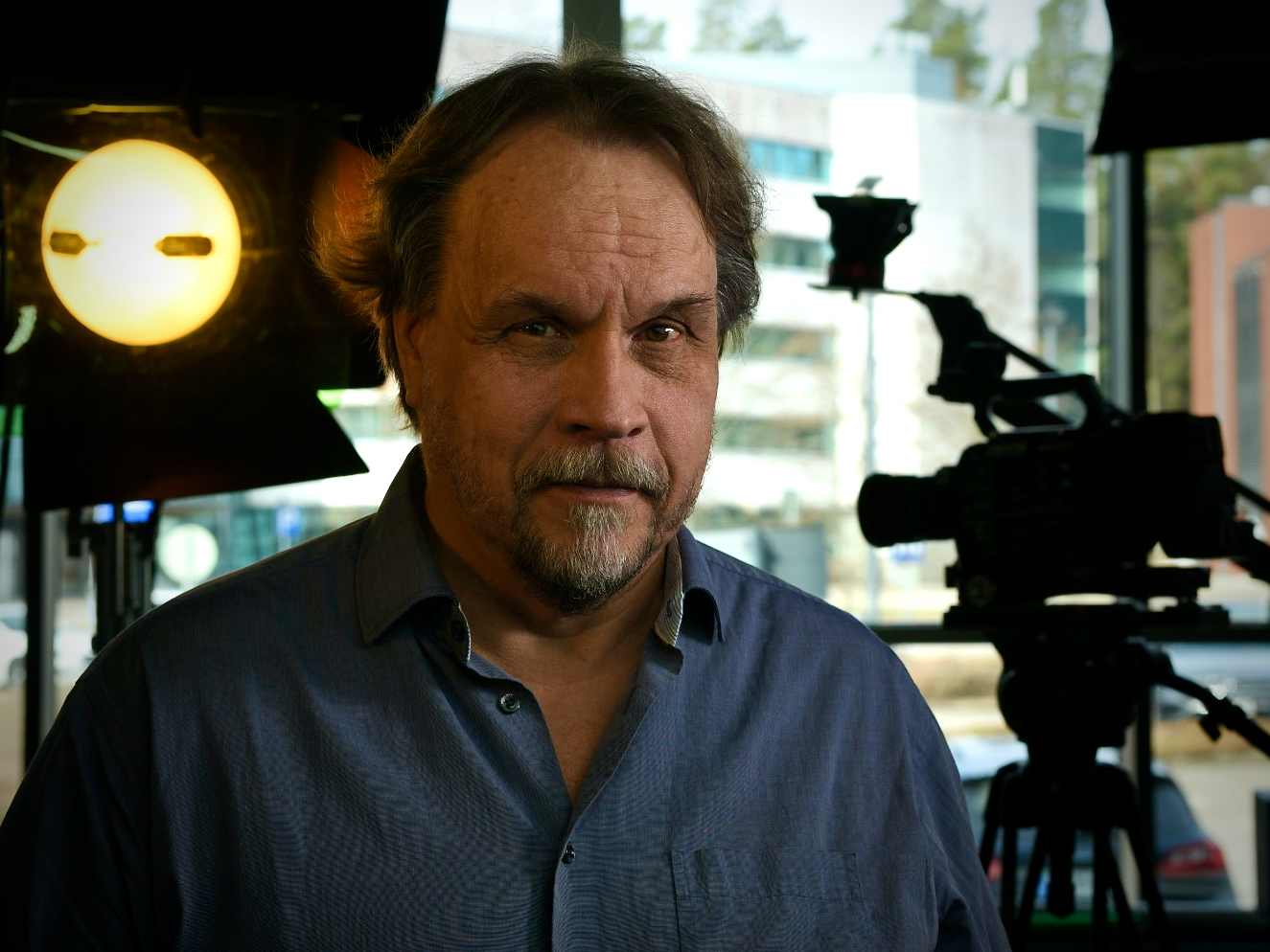 Kuva Harri Pulliaisesta, taustalla videokuvauskamera ja valo