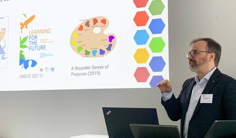 A man explaining in front of a classroom.