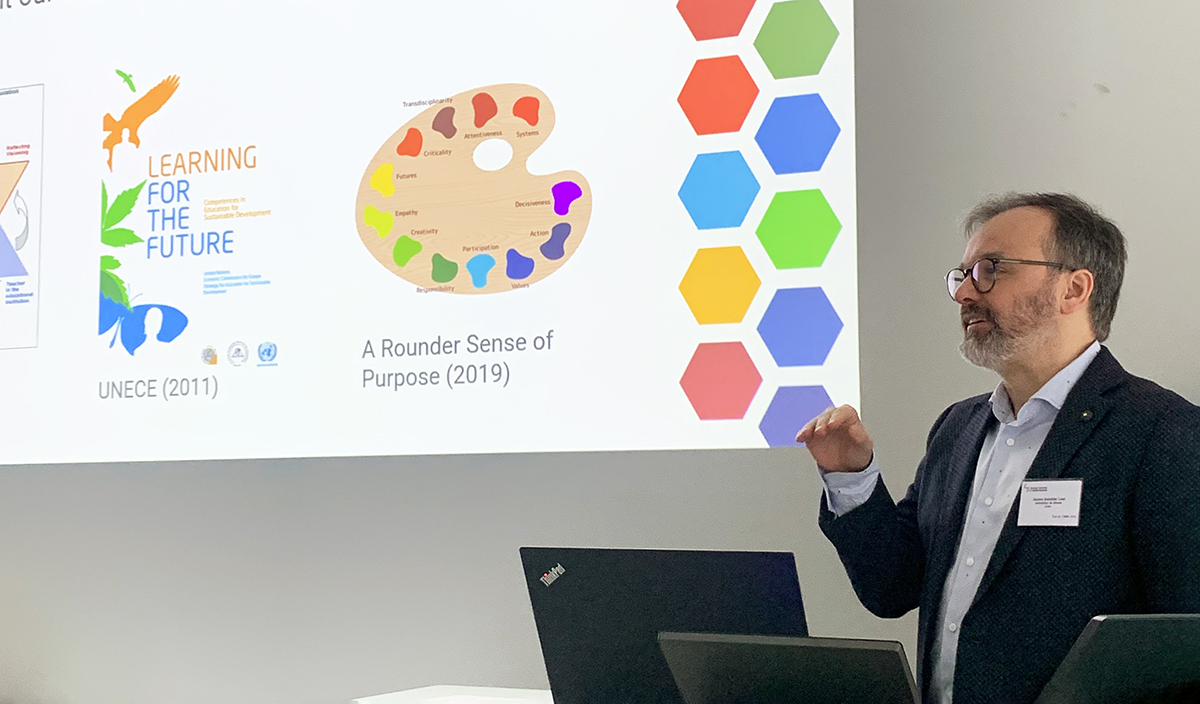 A man explaining in front of a classroom.