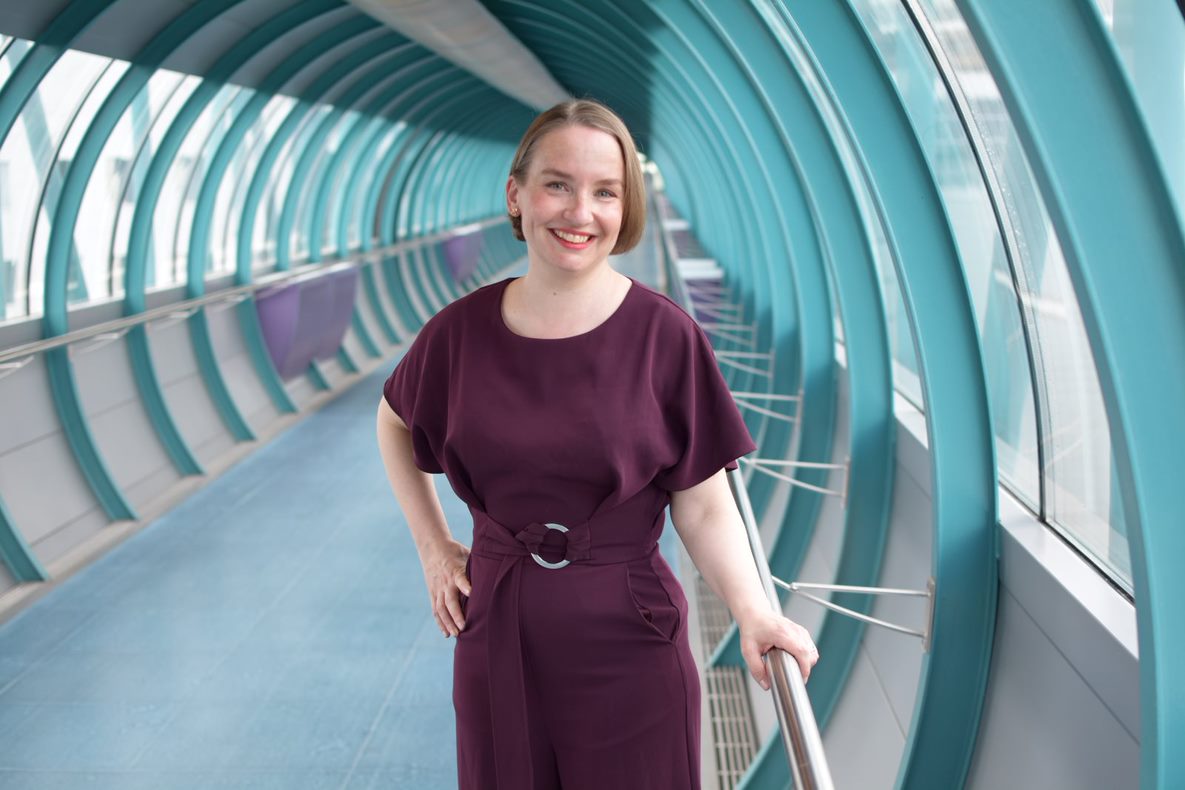 Idastiina Valtasalmi hymyilee kameralle Tampereen yliopiston kulkuputkessa.