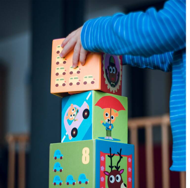 Lapsi kokoaa värikkäitä palikoita.