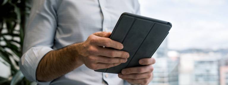 Mies pitelee tablettia.