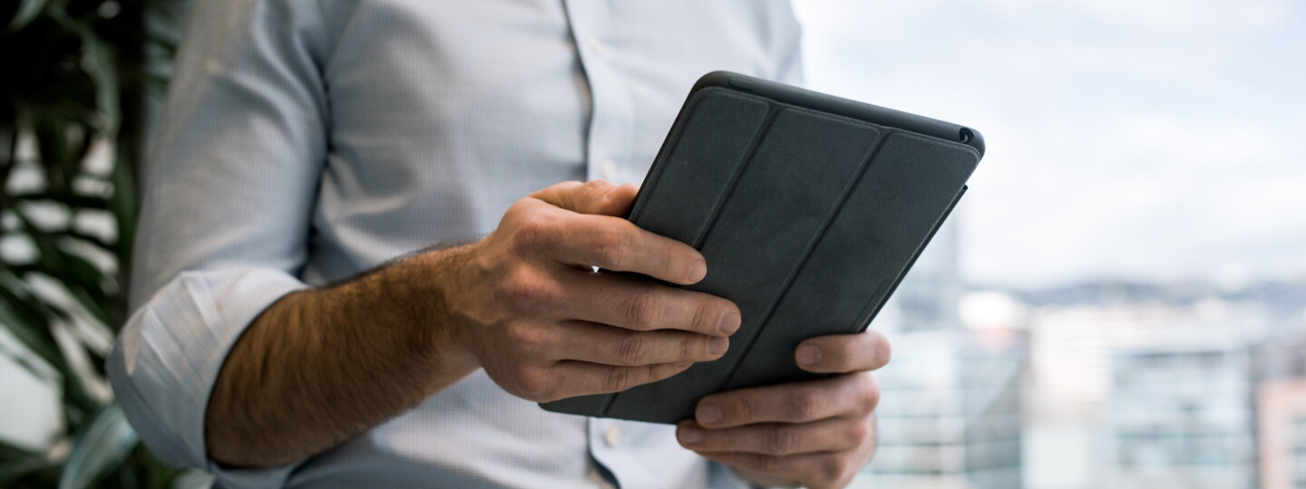 Mies pitelee tablettia.