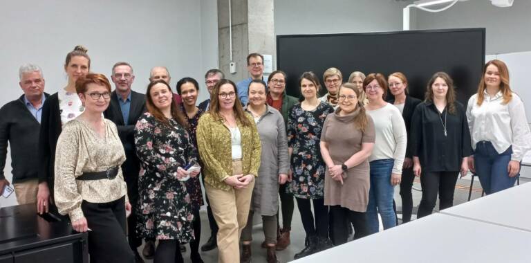 Tilaisuuden osallistujat ryhmäkuvassa.