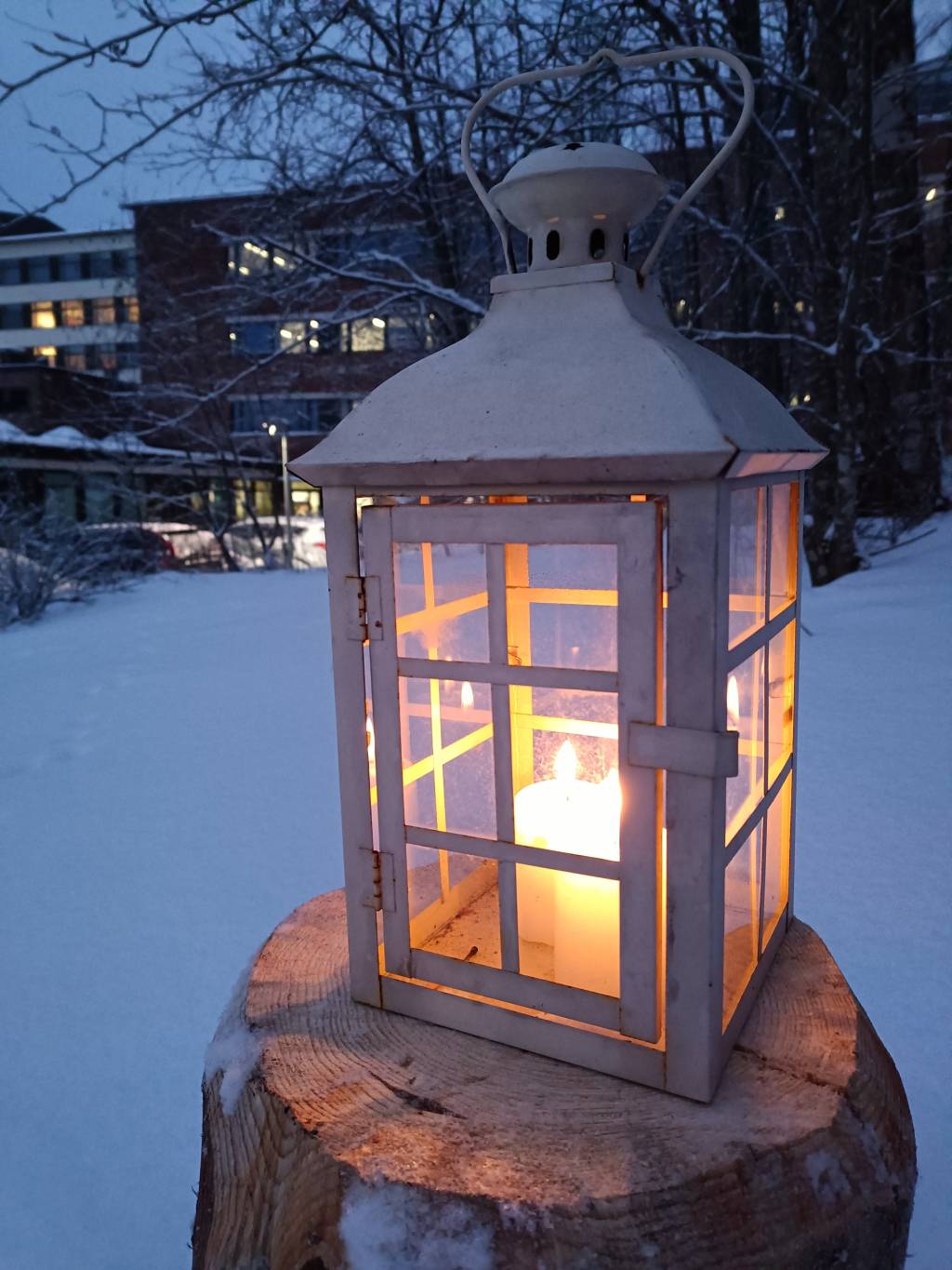 Valkoinen lyhty puupöllillä