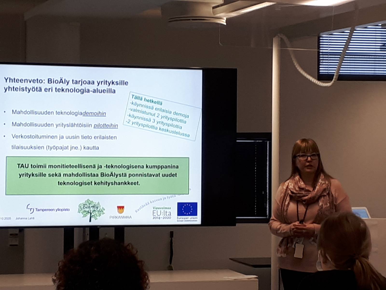 Projektikoordinaattori Johanna Lahti pitää esitelmää valkokankaan vieressä