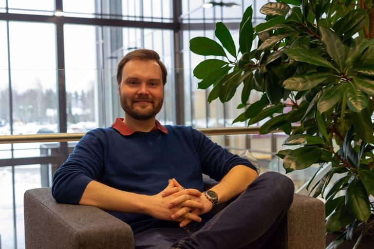 Hymyilevä mies nojatuolissa.