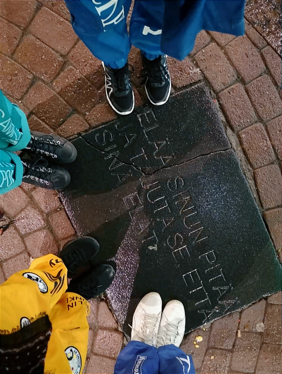 kuvassa näkyy neljän henkilön jalat, kaikilla on opiskelijahaalarit päällä. Haalareissa näkyy haalarimerkkejä.