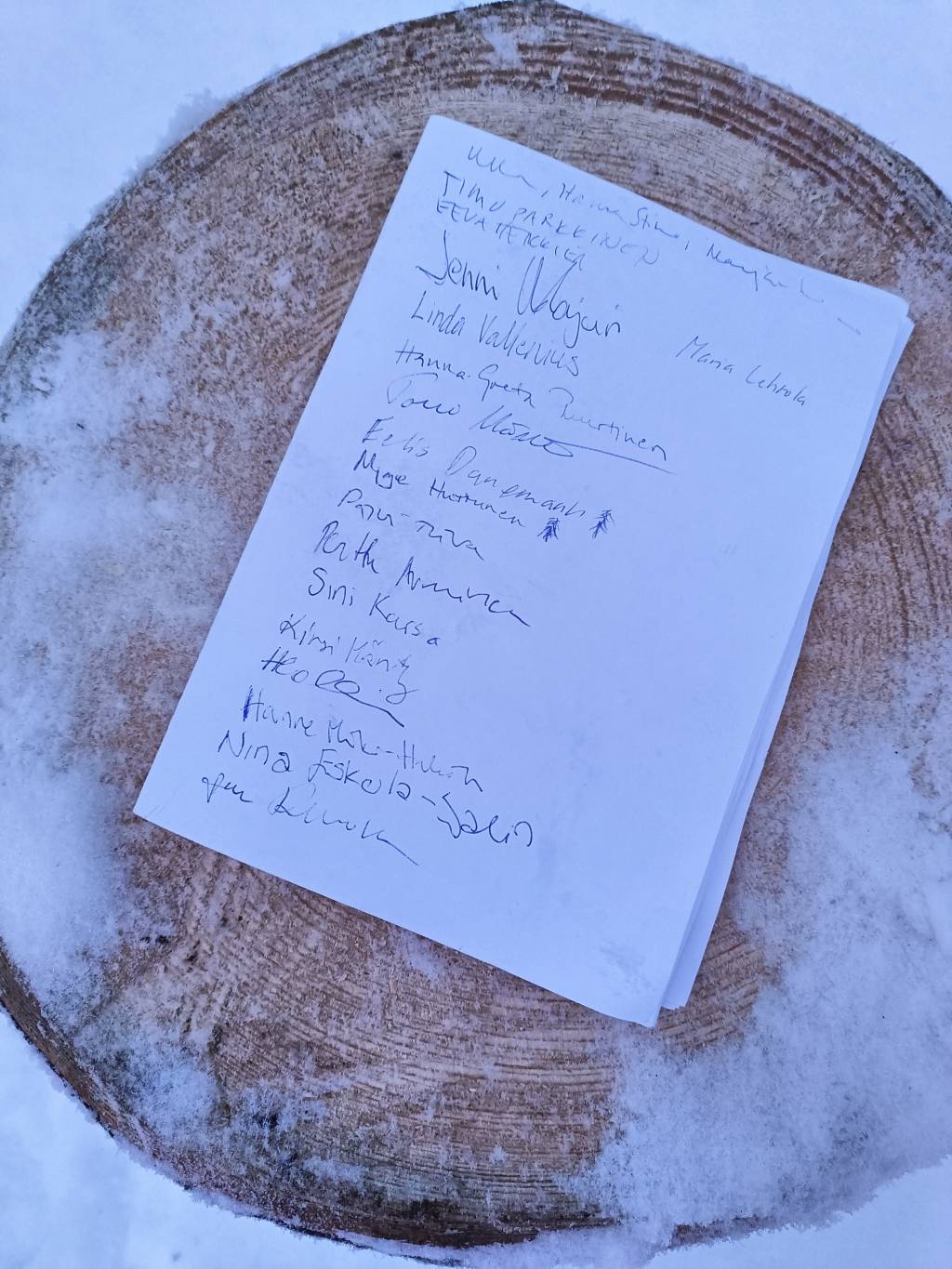 Vieraskirjan sivu lumisen puupölkyn päällä