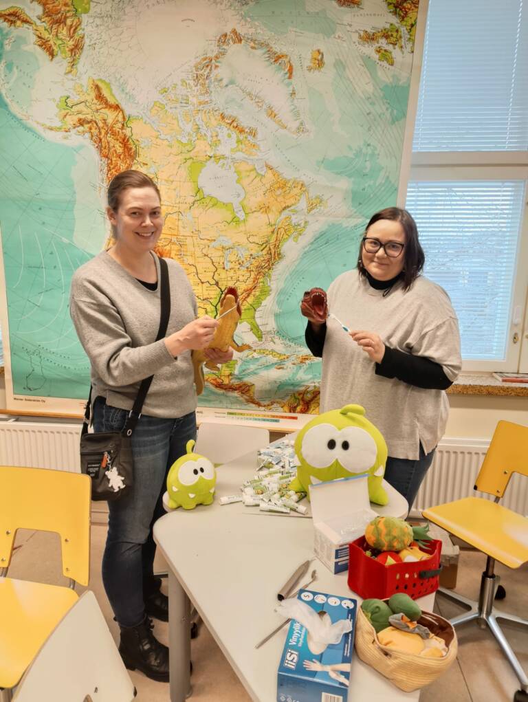 Hanketyöntekijät esittelevät suun terveyden edistämisen pistettä.