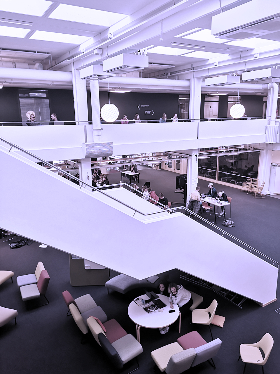 Ihmisiä opiskelemassa avarissa Kielikeskuksen tiloissa.