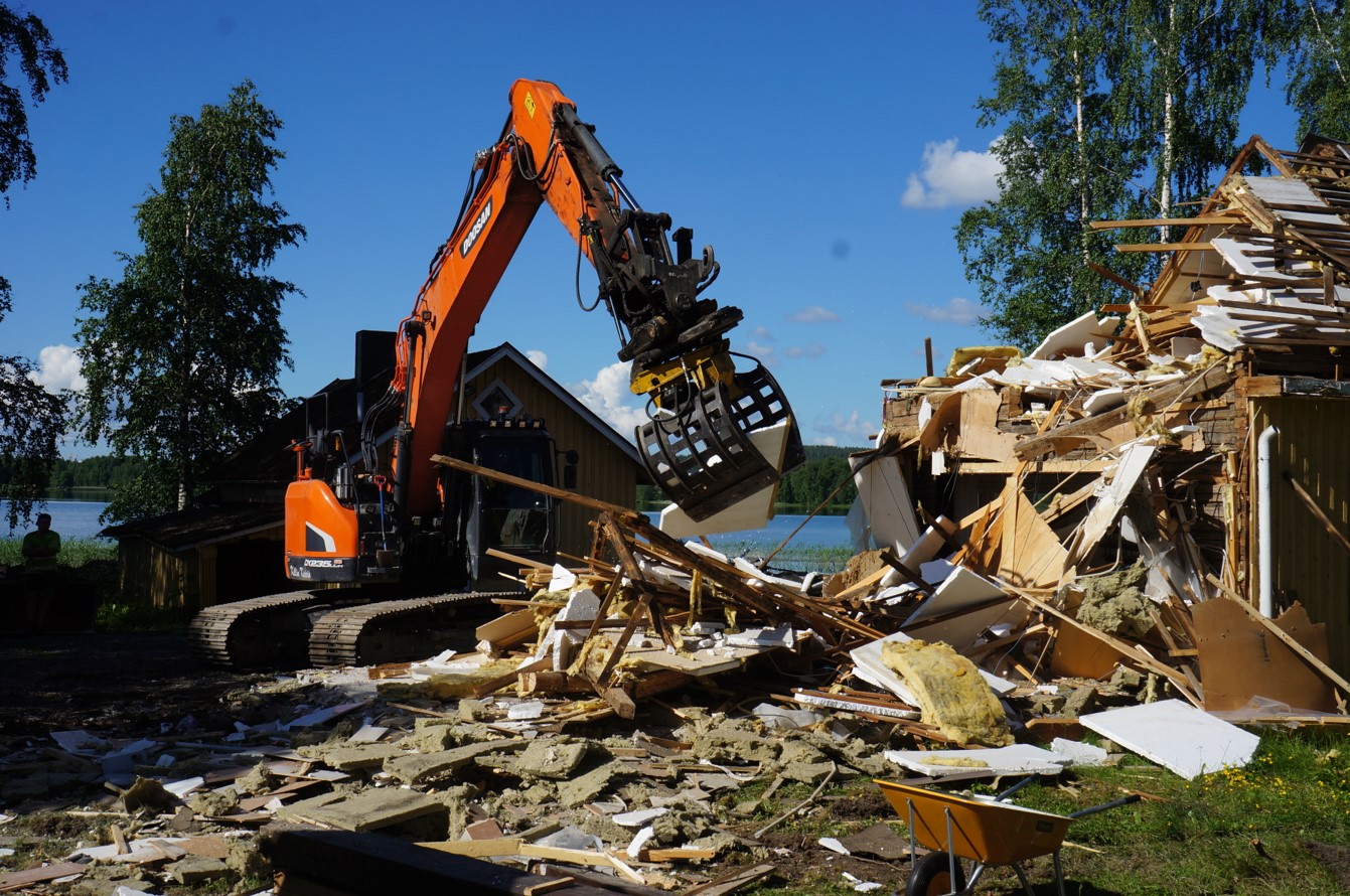 Talon purkamista kaivinkoneella