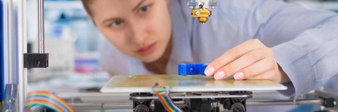 Nainen käyttää 3D-tulostinta