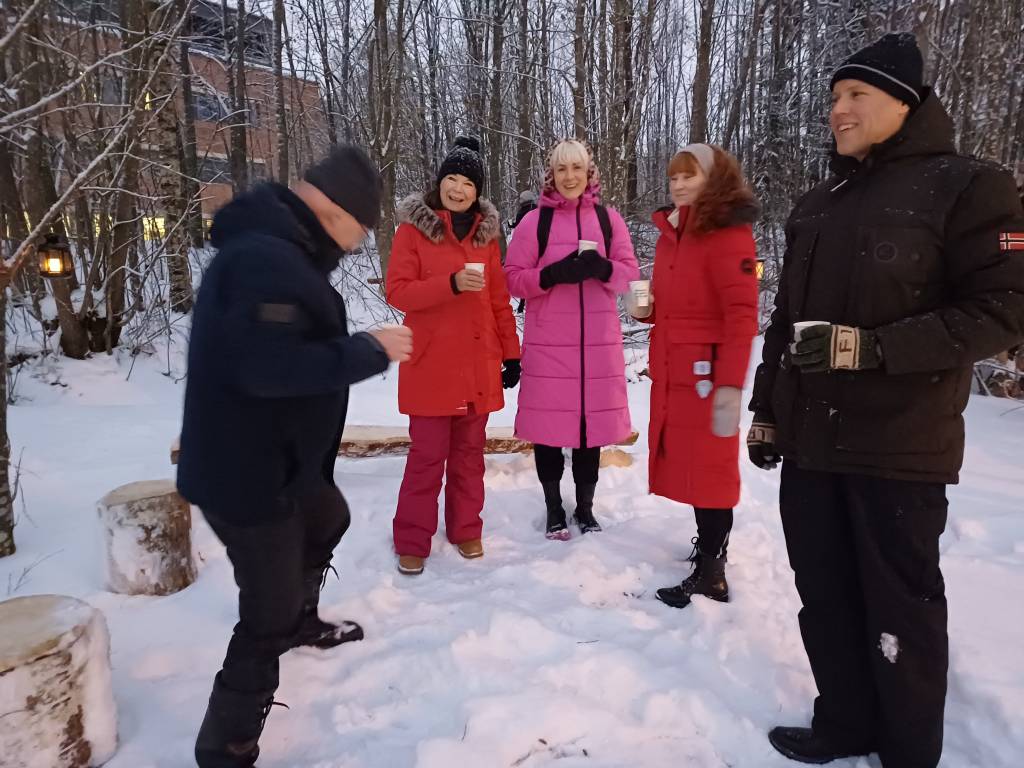 Iloista väkeä glögimukien kanssa Metsälämpäreellä