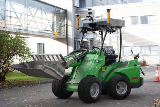 Green wheel loader equipped with cameras and LIDAR.