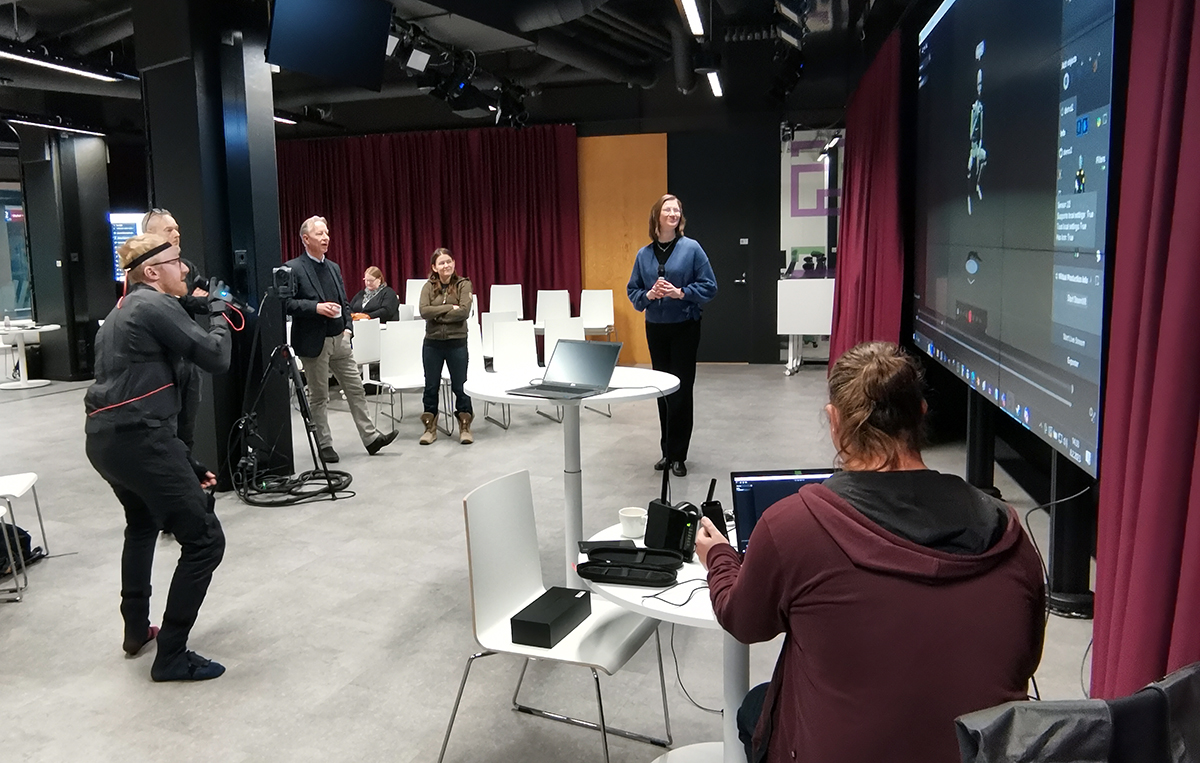 Henkilö esittelee sensoripukua yleisölle.