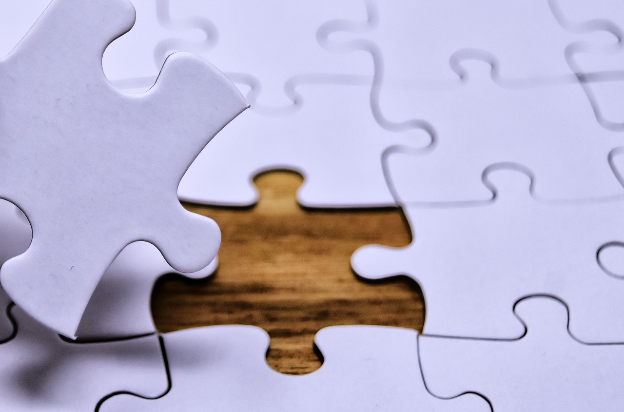 Palapelin palasia, joista keskeltä yksi puuttuu, mutta pilkottaa kuvan vasemmasta reunasta.