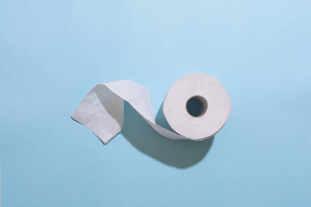 In English: A toilet roll on a blue background. Suomeksi: WC-rulla sinistä taustaa vasten.
