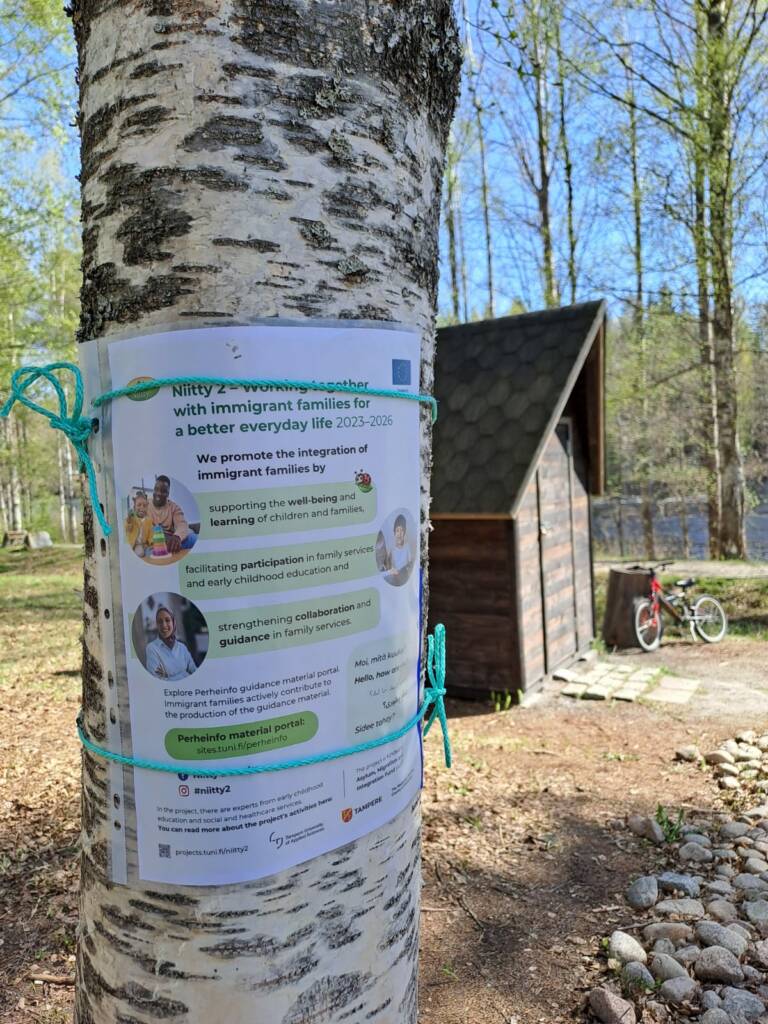 Hankkeen mainos kiinnitettynä puuhun.