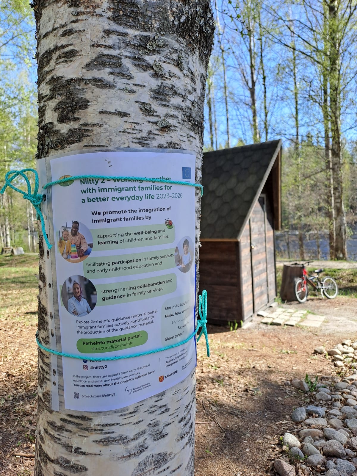 Hankkeen mainos kiinnitettynä puuhun.