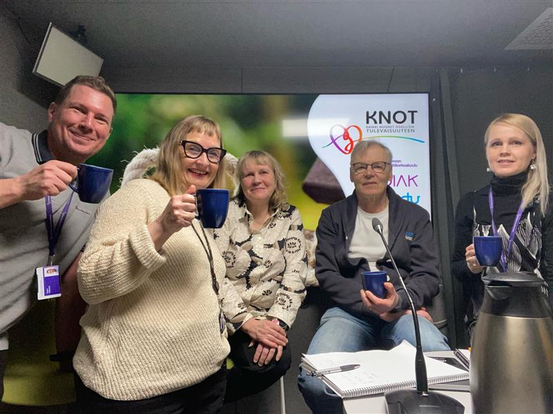 Viisi ihmistä ja kahvikupit.