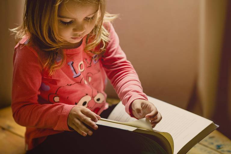 A child browsing a book. A photo by Jonathan Borba on Unsplash.