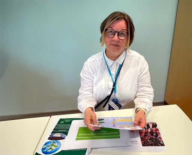 A woman holdng brochures in her hand.