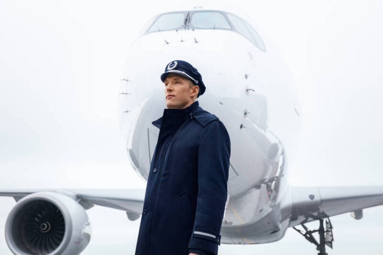 A pilot standing in front of an airplane.