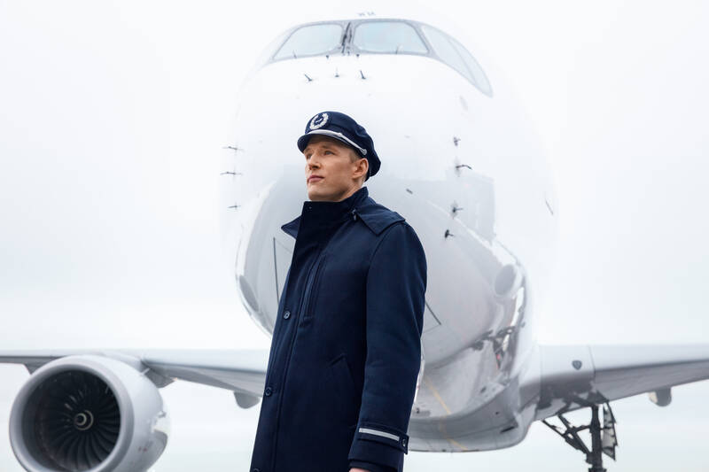A pilot standing in front of an airplane.