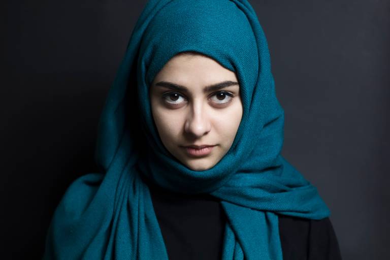 Nainen katsoo suoraan kameraan.