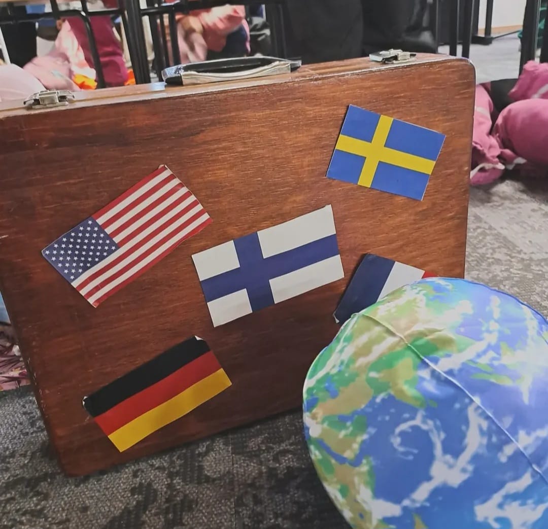 Kuvassa matkalaukku, jossa on eri maiden lippuja.