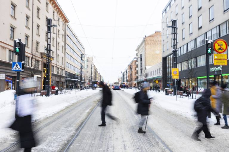 Ihmisiä ylittämässä tietä Tampereen keskustassa.