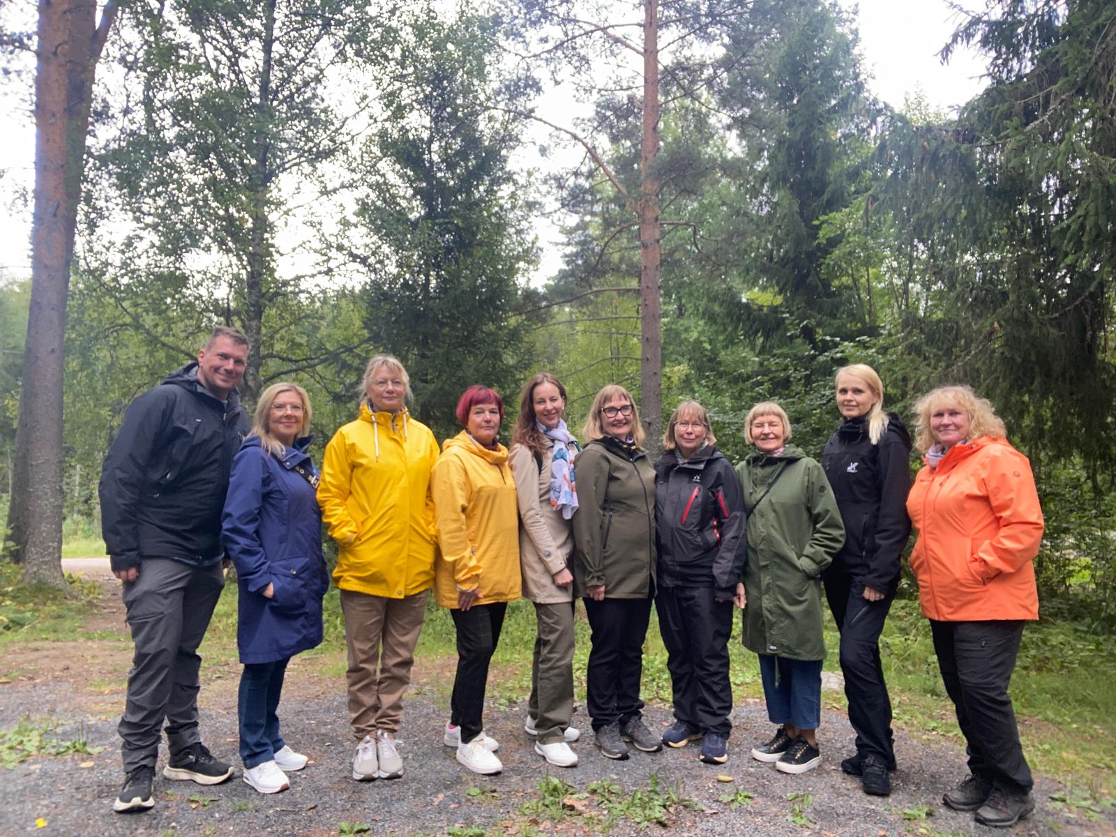 Ihmisiä rivissä luonnossa