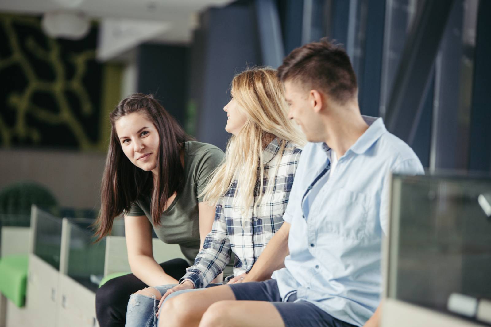 Kolme nuorta istumassa vierekkäin