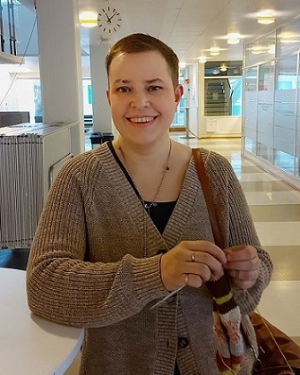 Kuvassa on hankkeen sarjakuvataiteilija ja tutkija H-P Ontto-Panula. H-P katsoo kameraan hymyillen ja hänellä on kädessään sukkapuikot.