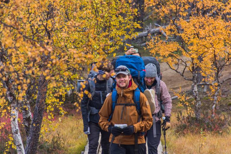 Seikkailupedagogiikan opiskelijoita vaeltamassa sykysyisessä luonnossa.